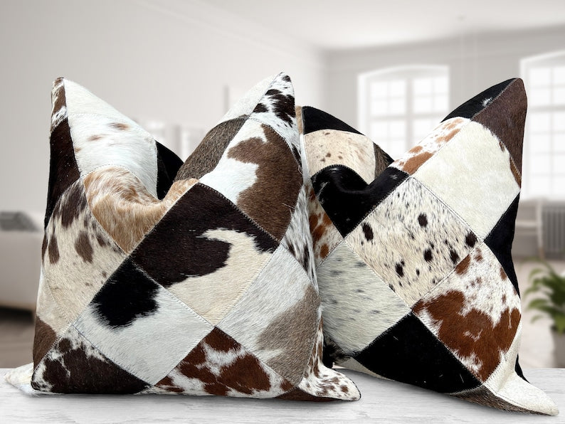 Pack of two genuine cow skin leather cushion covers with a mixed tricolor design of black, brown, and white, showcasing unique patterns.