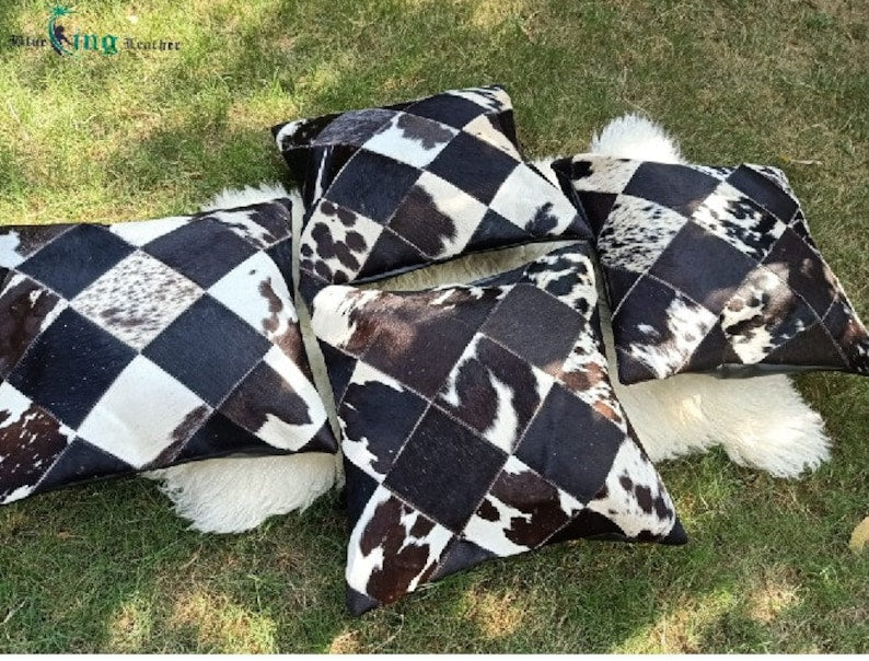 Pack of two genuine cow skin leather pillow covers with unique tricolor patterns in black, brown, and white, showcasing a luxurious texture.