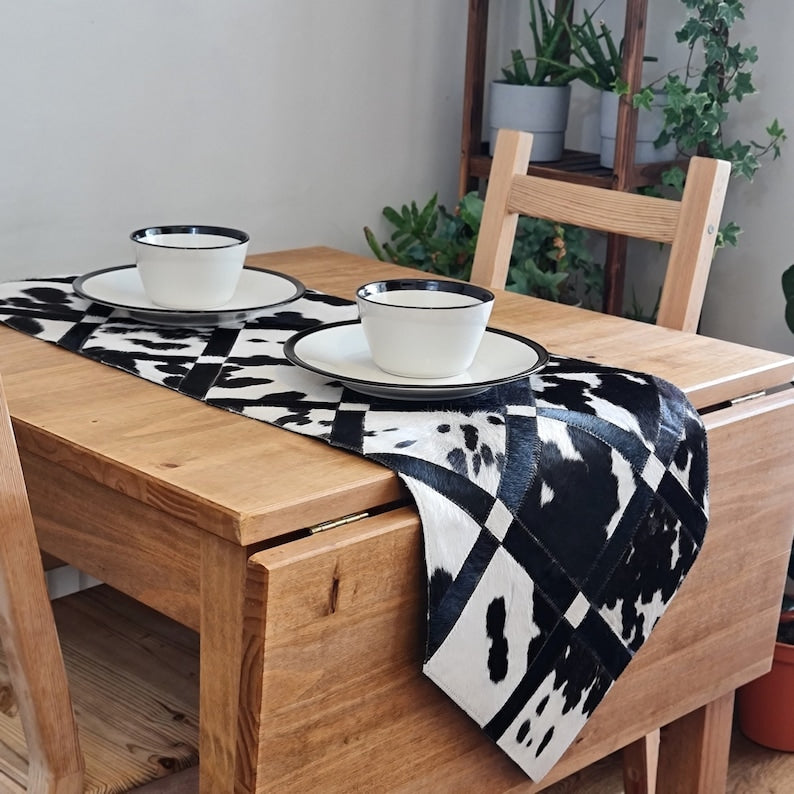 Pack of two handmade cowhide table runners, 16" x 60", showcasing unique patterns and colors.