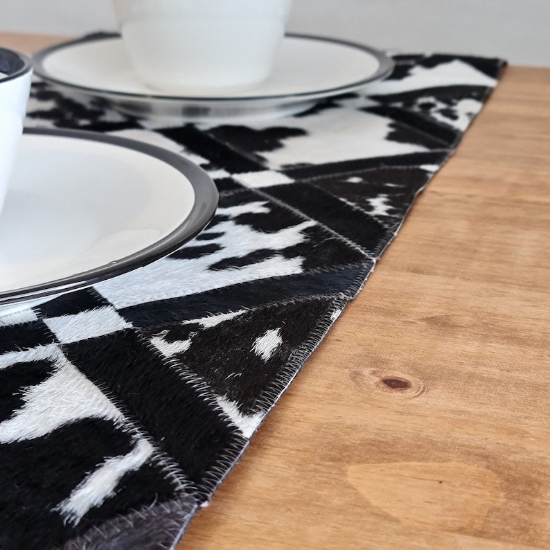 Pack of two handmade cowhide table runners, 16" x 60", showcasing unique patterns and colors.