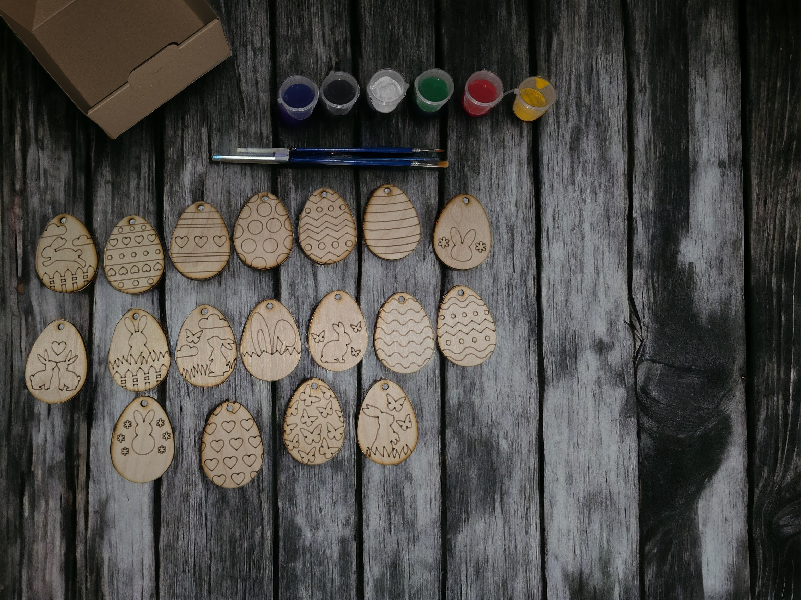 A colorful assortment of paintable plywood Easter eggs, featuring various designs and vibrant colors, perfect for kids' crafting activities.