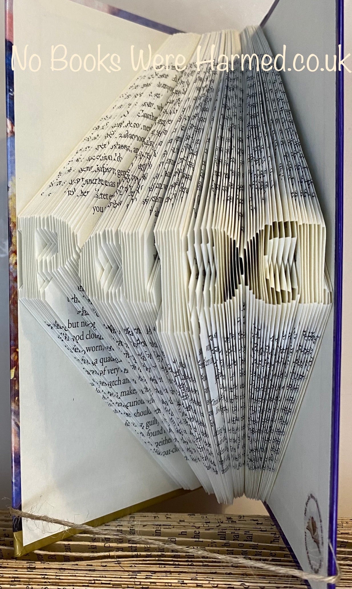 Hand-folded book art piece named 'Papa', crafted from vintage books, showcasing intricate folds and unique colors.