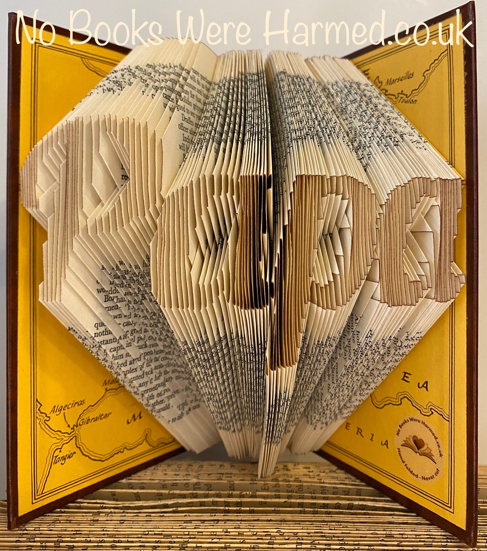 Hand-folded book art piece named 'Papa', crafted from vintage books, showcasing intricate designs and unique colors.