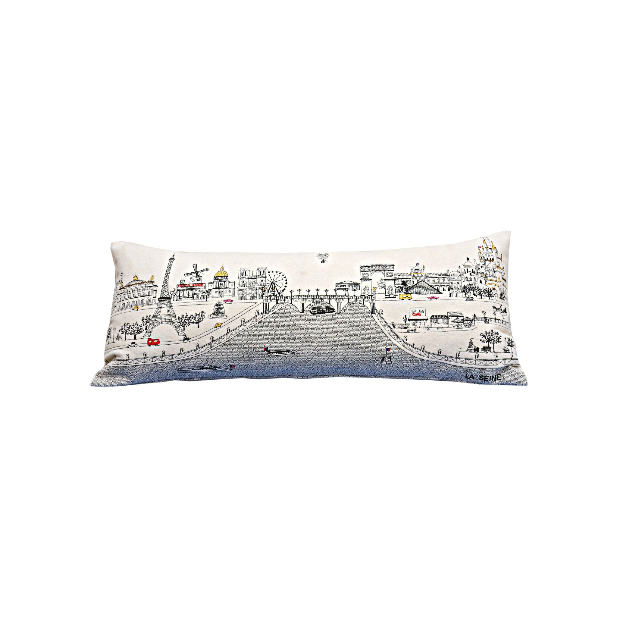 A decorative pillow featuring iconic Parisian landmarks like the Eiffel Tower and Notre-Dame Cathedral, with a red zipper at the bottom.