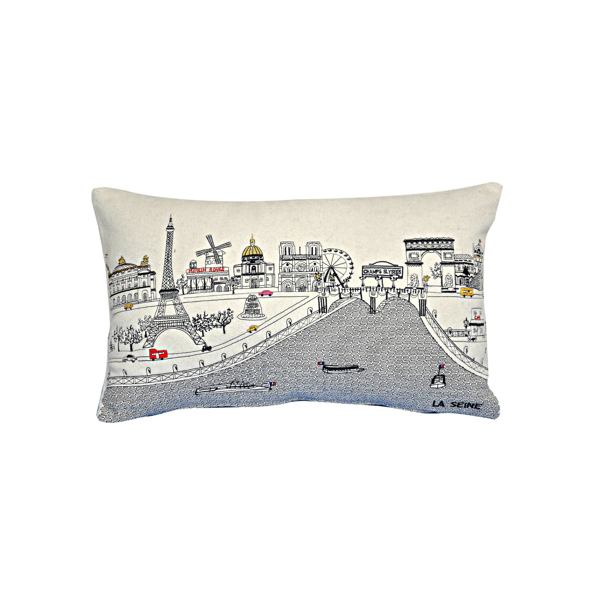 A decorative pillow featuring iconic Parisian landmarks like the Eiffel Tower and Notre-Dame Cathedral, with a red zipper at the bottom.