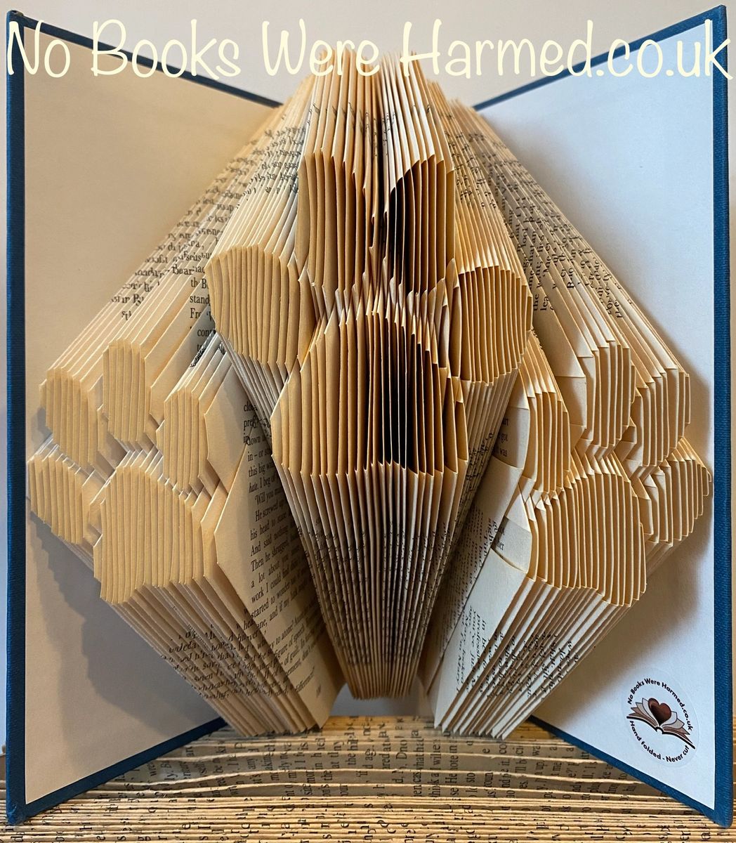 Hand-folded book art piece titled Paws: Triple Paws, showcasing intricate designs made from vintage book pages.