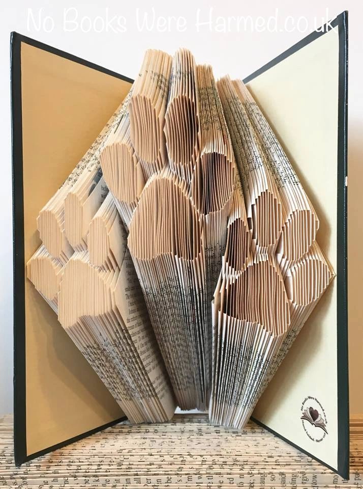 Hand-folded book art piece titled Paws: Triple Paws, showcasing intricate designs made from vintage book pages.