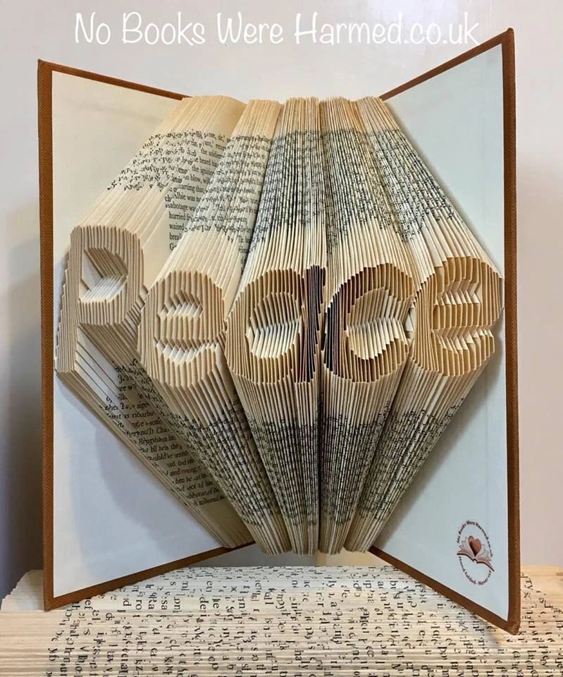 Hand-folded book art titled 'Peace', showcasing intricate designs from vintage book pages.