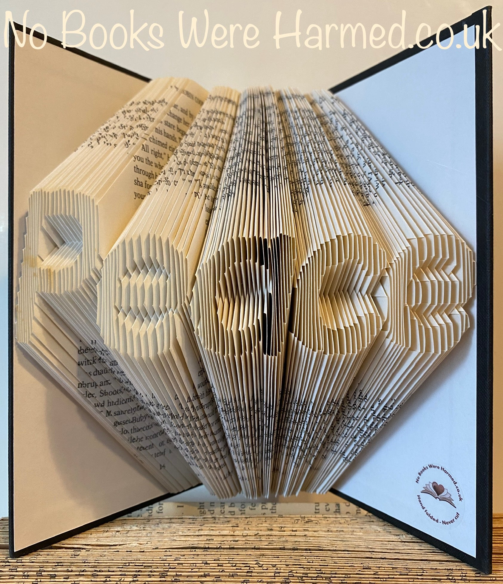 Hand-folded book art titled 'Peace', showcasing intricate designs from vintage book pages.