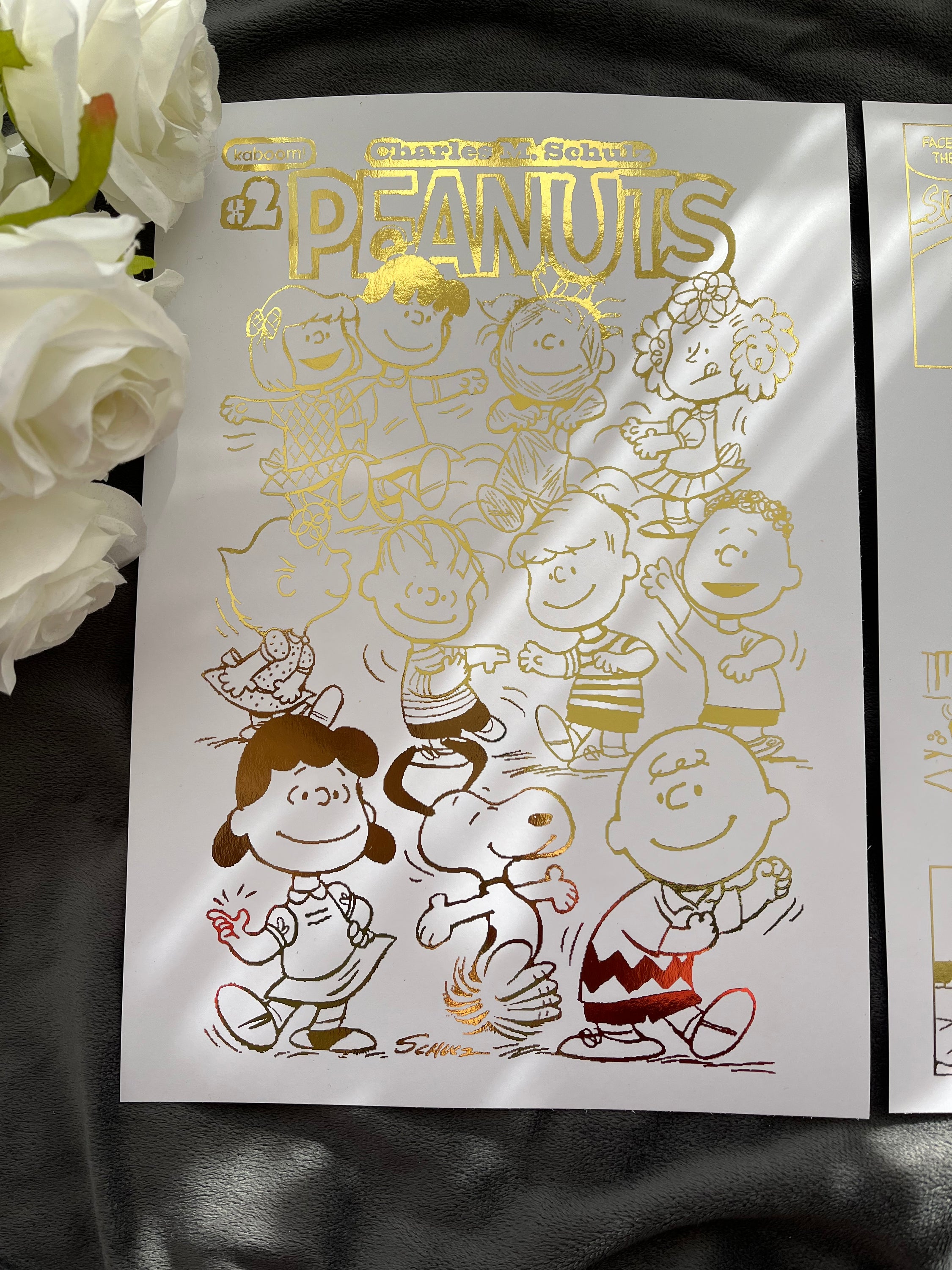 Peanuts Comic Cover & Comic Strip Foil Print featuring Charlie Brown, Snoopy, and other iconic characters in gold foil accents.