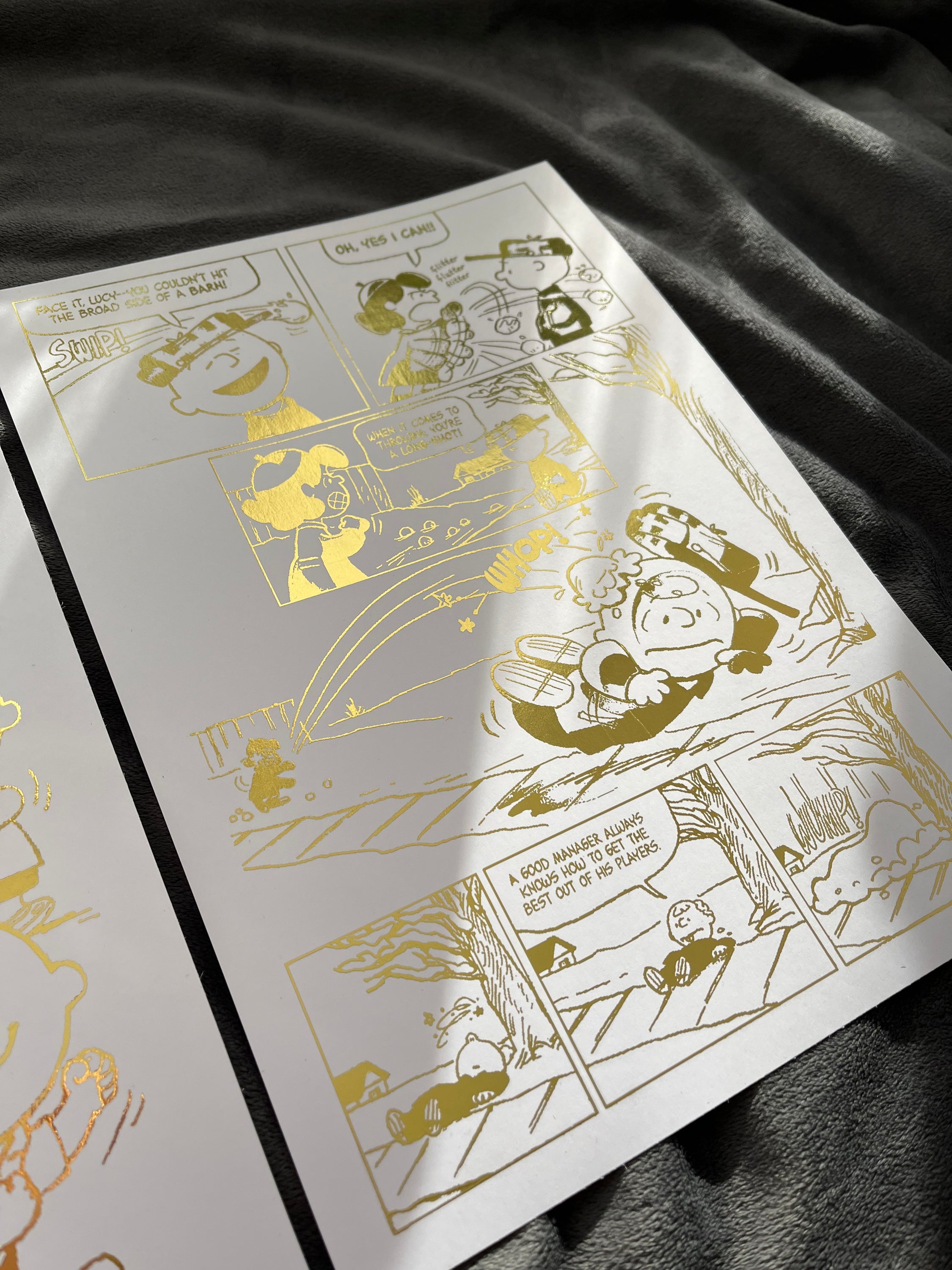 Peanuts Comic Cover & Comic Strip Foil Print featuring Charlie Brown, Snoopy, and other iconic characters in gold foil accents.