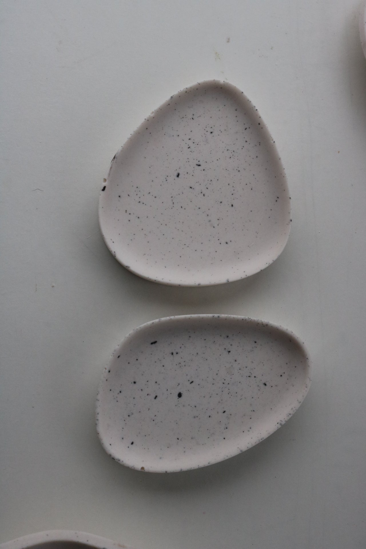 A pair of hand-made Pebble dishes in various colors and patterns, showcasing their unique textures and finishes.