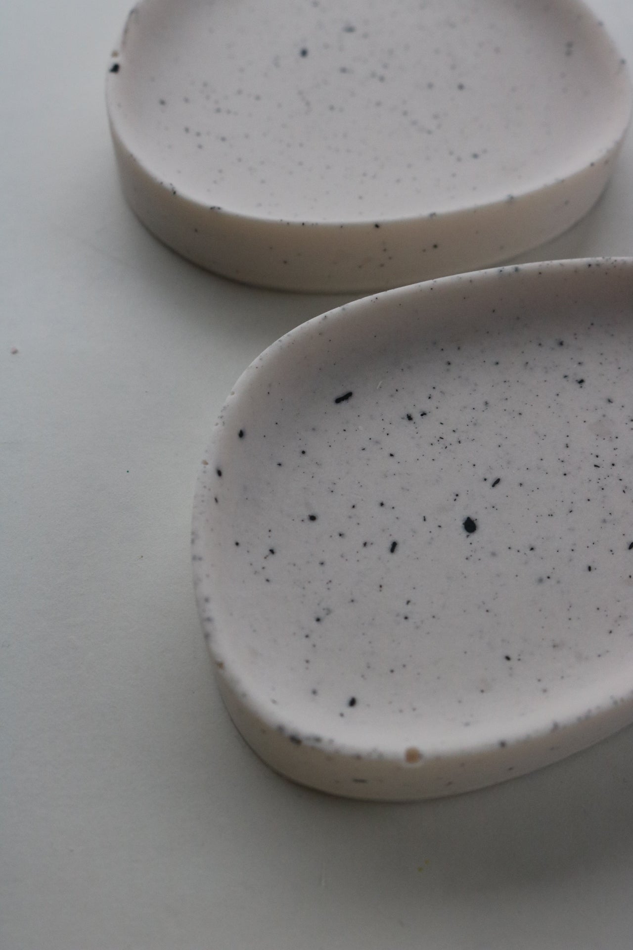 A pair of hand-made Pebble dishes in various colors and patterns, showcasing their unique textures and finishes.