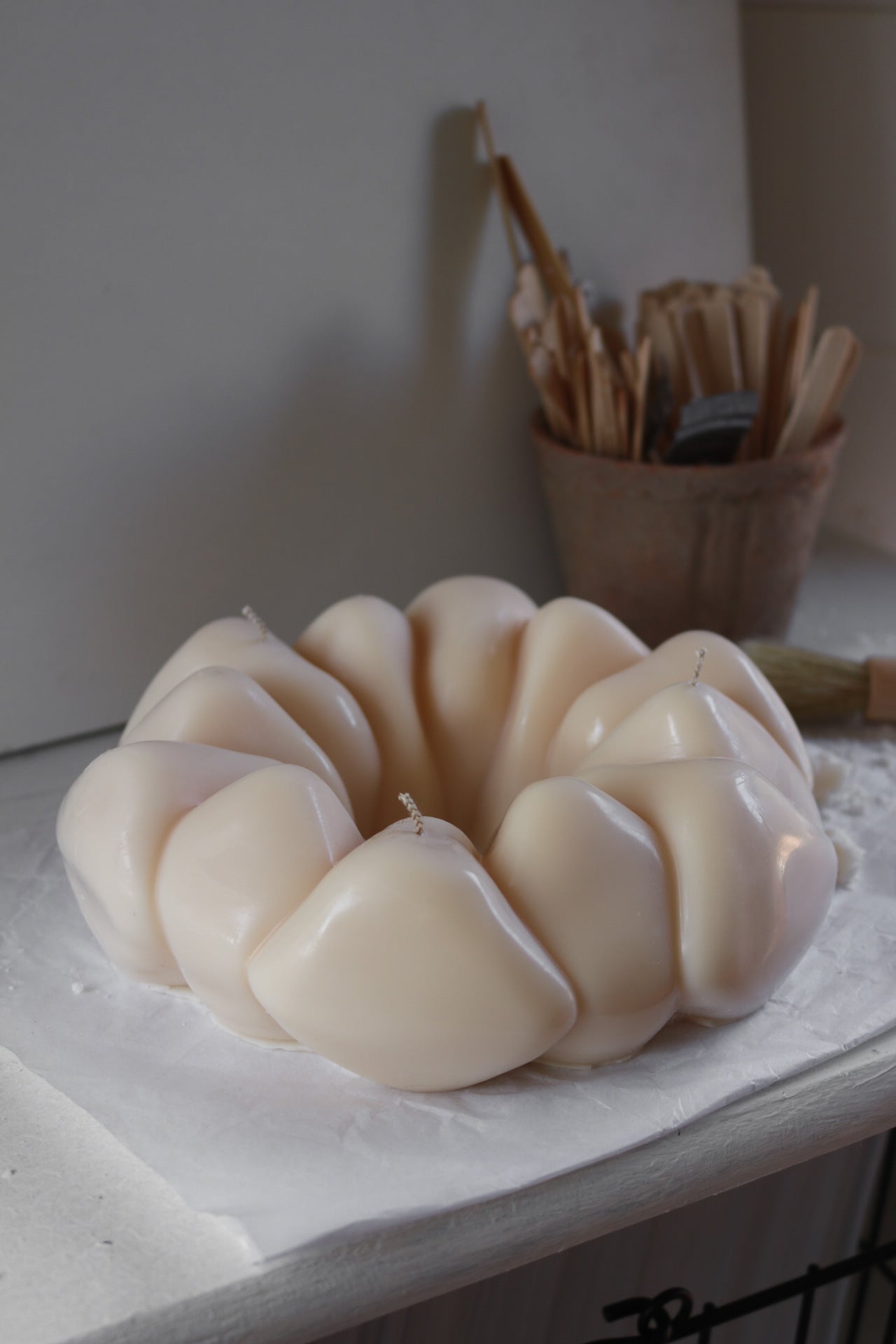 A beautifully crafted pebble wreath candle made from a soy wax blend, showcasing its sculptural design and neutral tones, perfect for home decor.