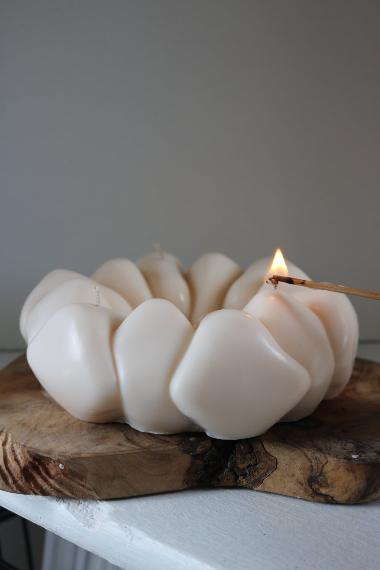 A beautifully crafted pebble wreath candle made from a soy wax blend, showcasing its sculptural design and neutral tones, perfect for home decor.