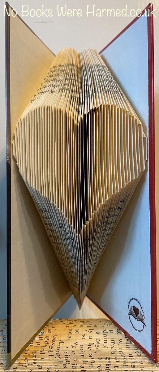 A handcrafted heart made from the pages of vintage books, showcasing intricate folds and unique textures.