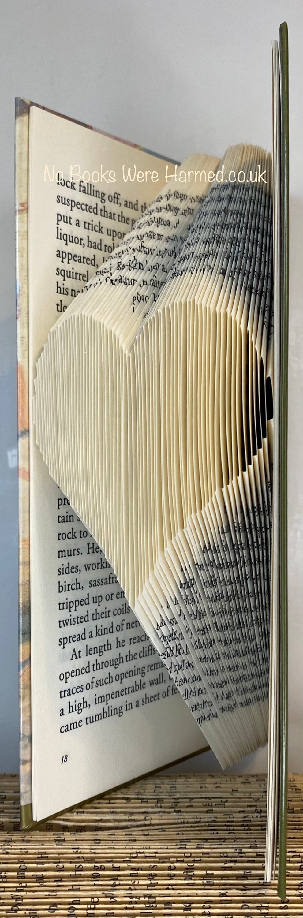 A handcrafted heart made from the pages of vintage books, showcasing intricate folds and unique textures.