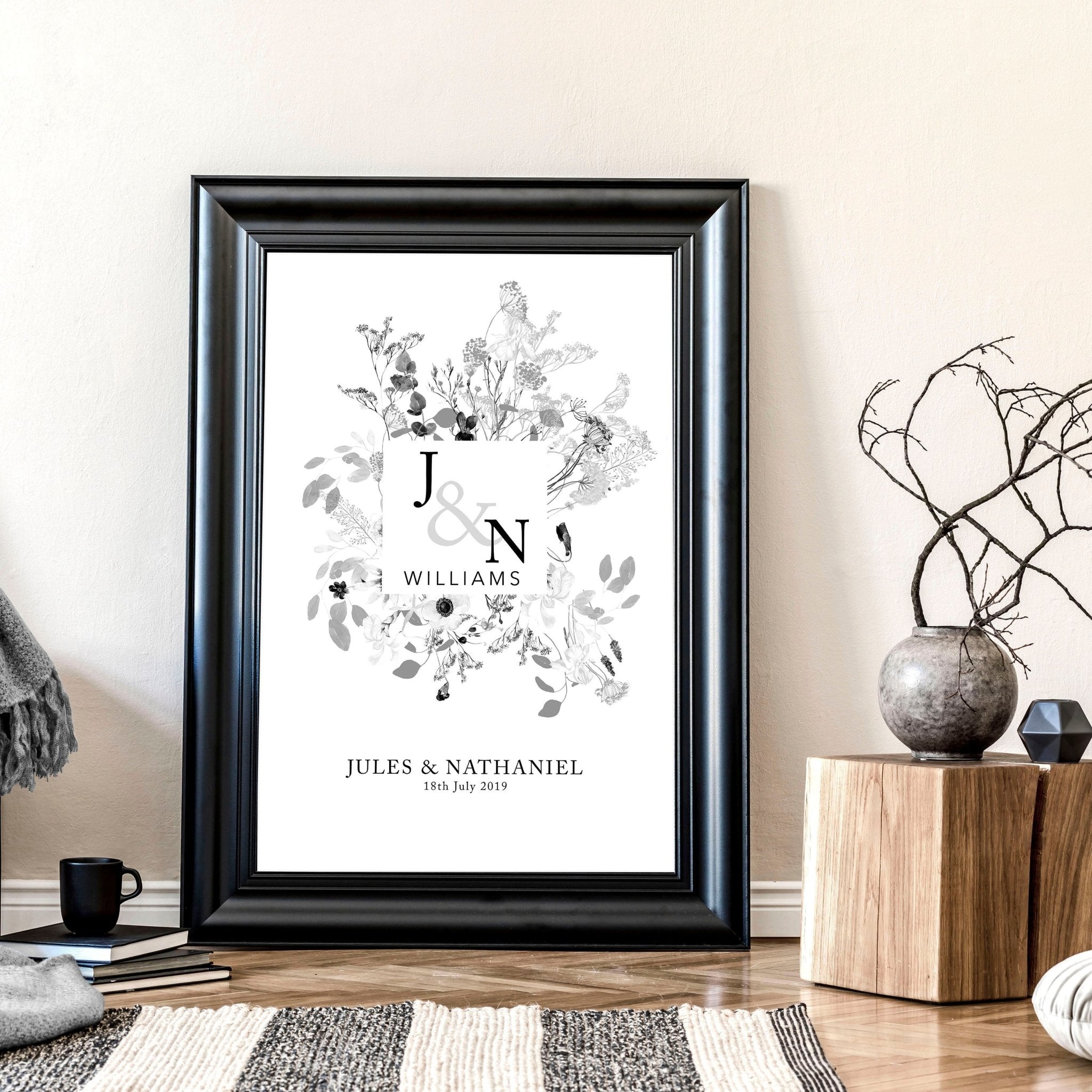 Personalised wedding anniversary wall art print featuring a botanical monogram design in neutral grey, customised with names and anniversary details.