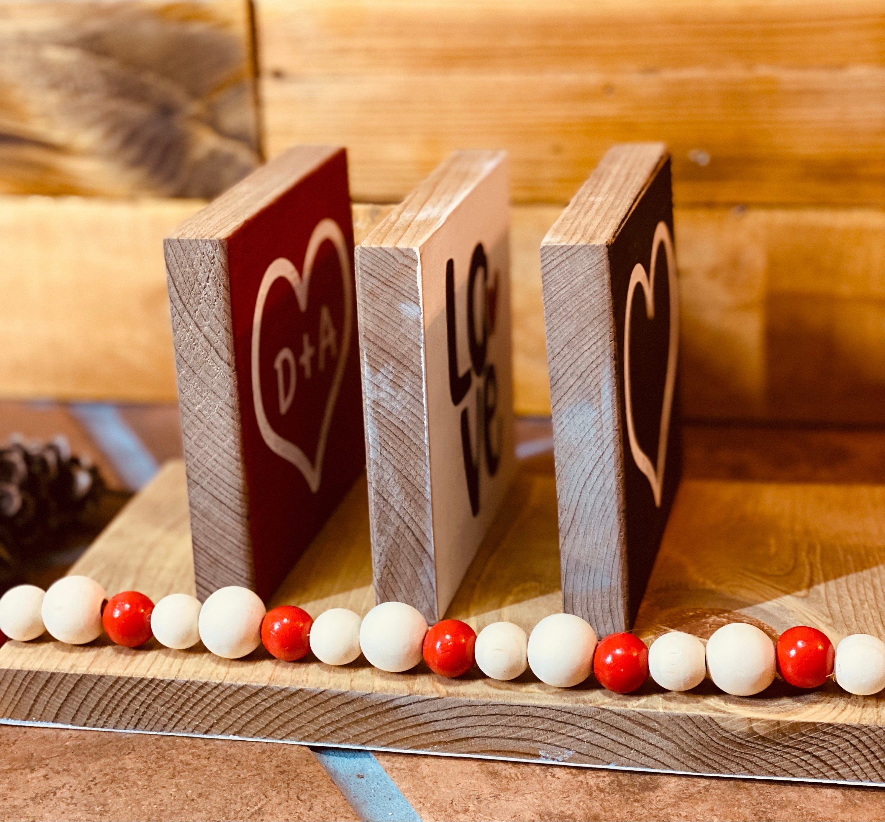 Personalized Valentine's Day Tiered Tray Set featuring hand-painted signs in red, black, and white with heart designs and initials.