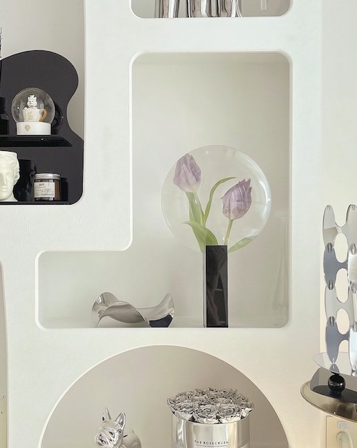 A modern decorative Phantom Vase showcasing a unique floating flower illusion, crafted from acrylic and metal, elegantly displayed with flowers.