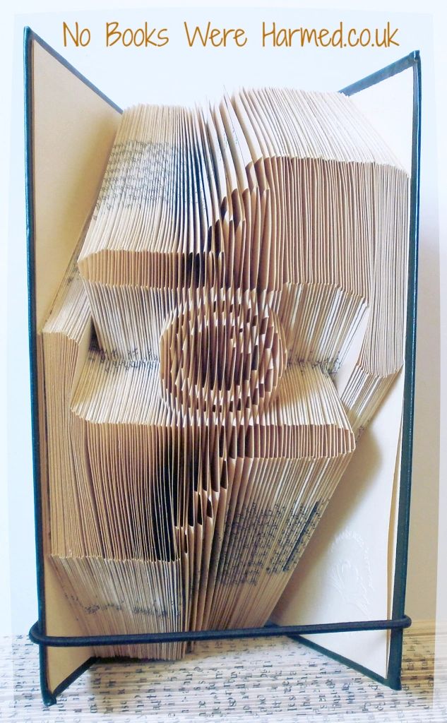 A beautifully crafted piece of book art featuring hand-folded pages from vintage books, showcasing intricate designs and textures.