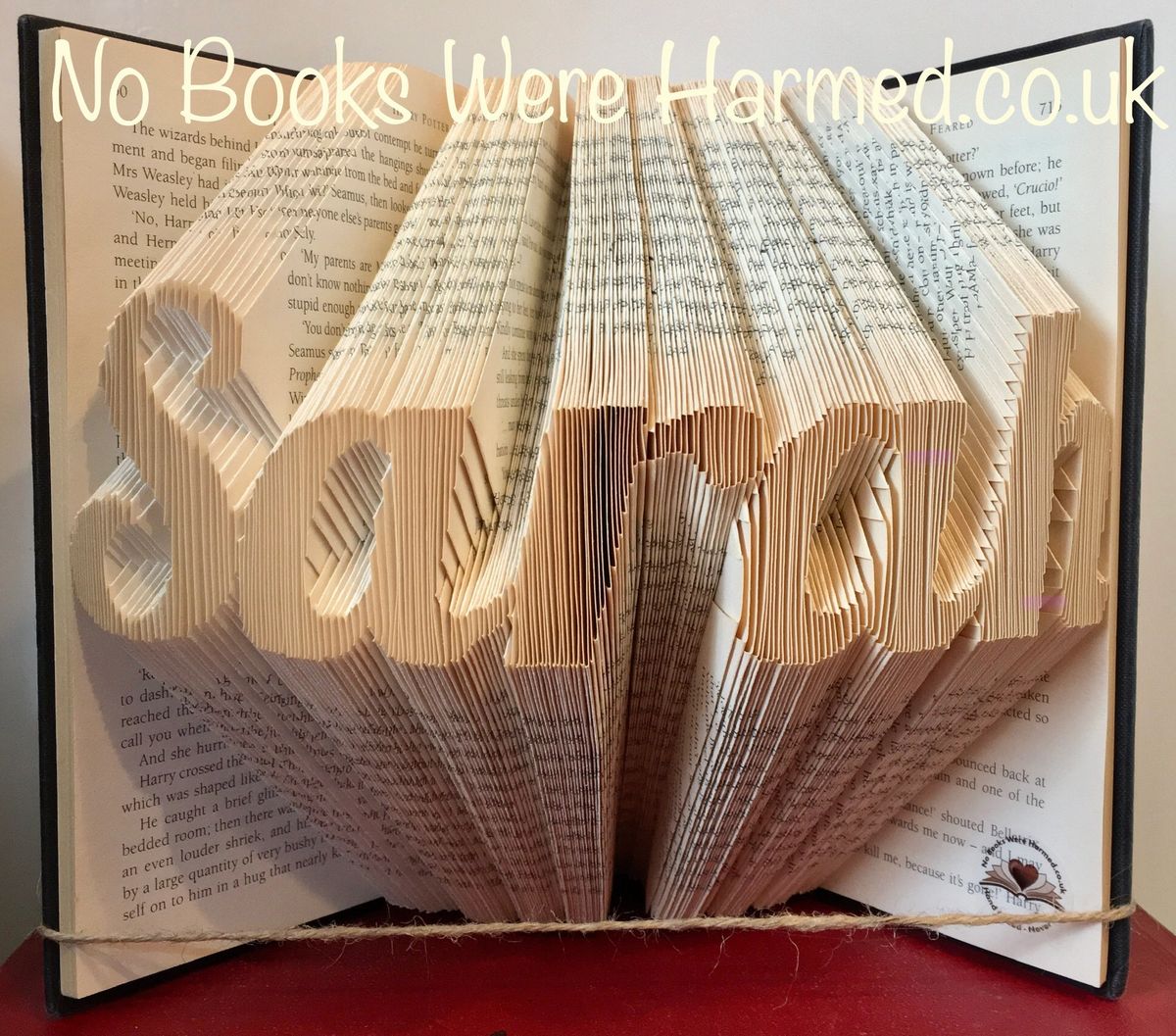 Hand-folded book art displaying custom words and punctuation, showcasing unique designs from vintage books.