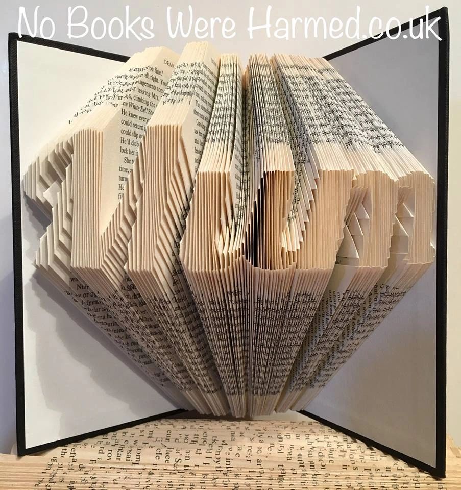 Hand-folded book art displaying custom words and punctuation, showcasing unique designs from vintage books.