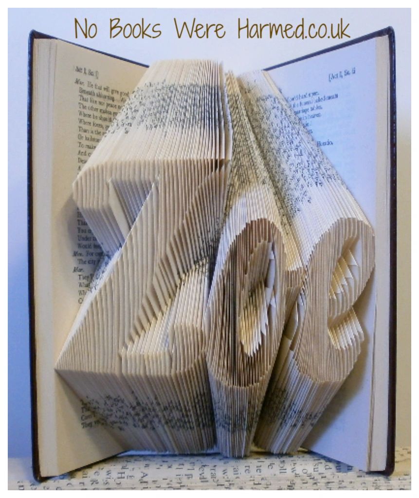 Hand-folded book art displaying custom words and punctuation, showcasing unique designs from vintage books.