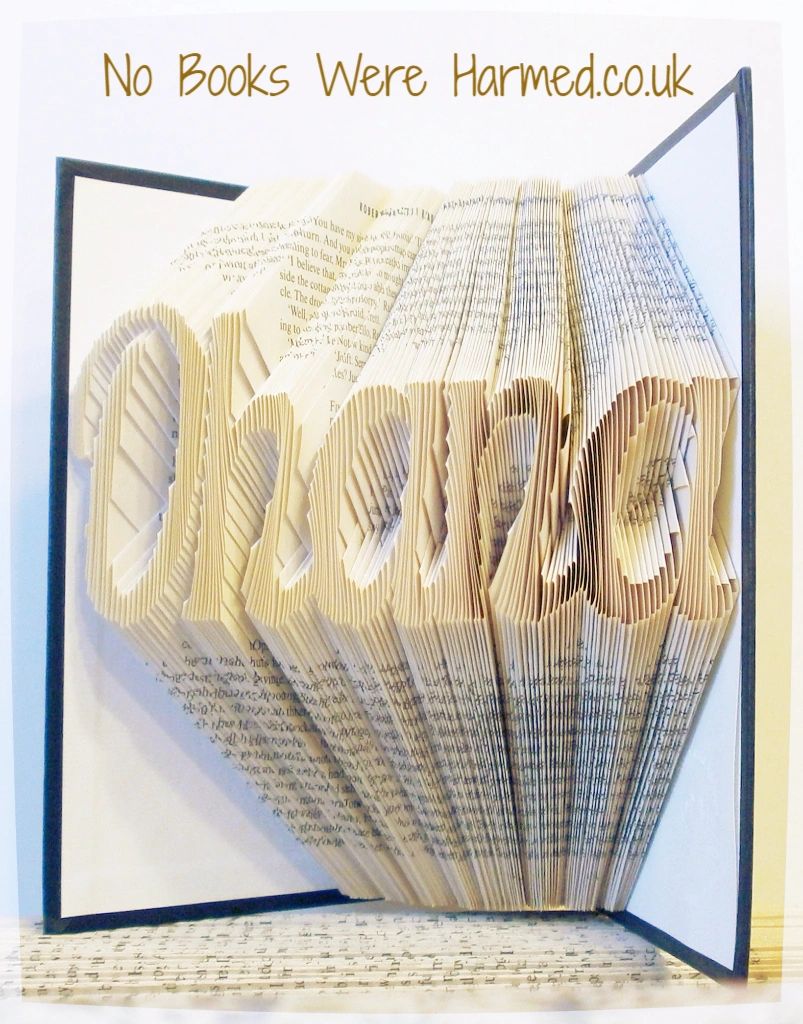 Hand-folded book art displaying custom words and punctuation, showcasing unique designs from vintage books.