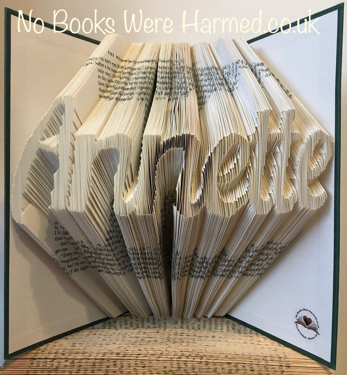 Hand-folded book art displaying custom words and punctuation, showcasing unique designs from vintage books.