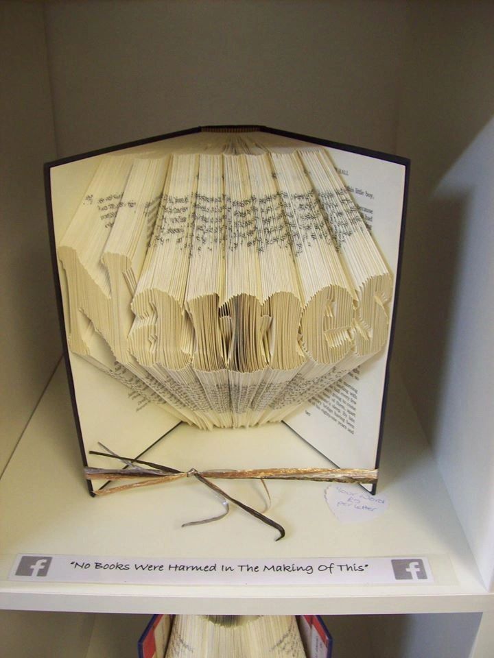 Custom book art featuring hand-folded letters from vintage books, showcasing unique designs and colors.