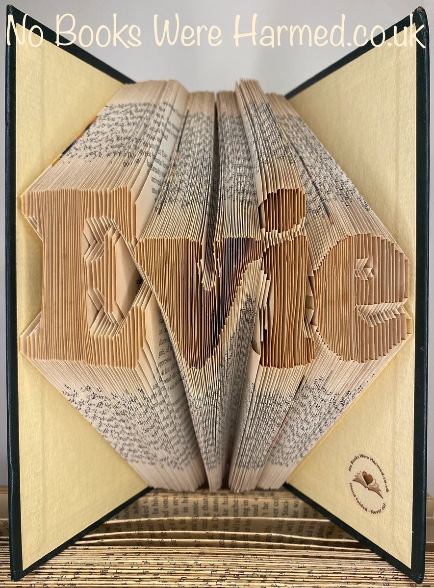 Custom book art featuring hand-folded letters from vintage books, showcasing unique designs and colors.