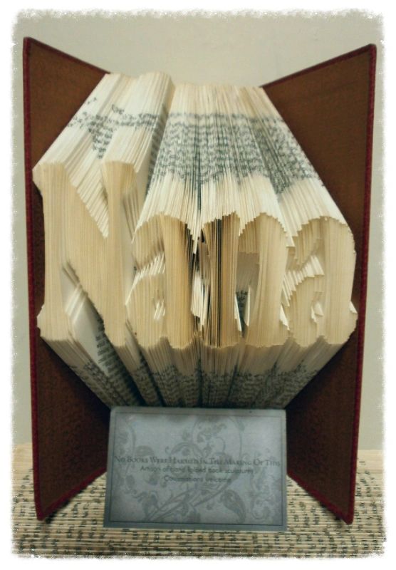 Custom book art featuring hand-folded letters from vintage books, showcasing unique designs and colors.