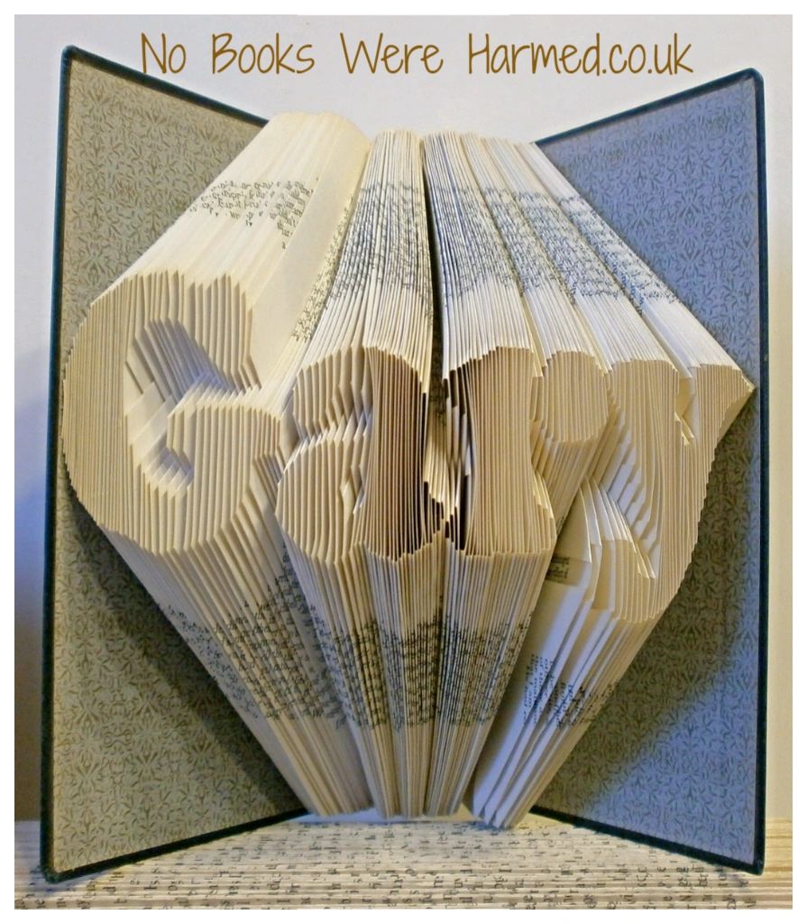 Custom book art featuring hand-folded letters from vintage books, showcasing unique designs and colors.