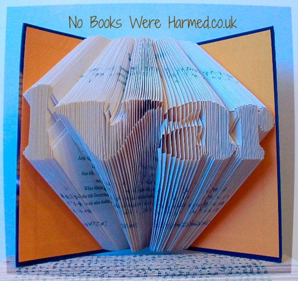 Custom book art featuring hand-folded letters from vintage books, showcasing unique designs and colors.