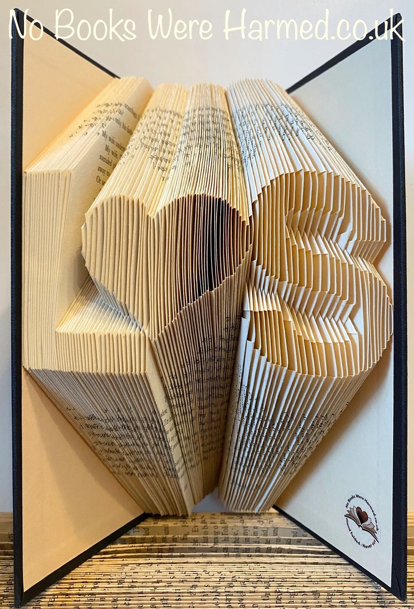 Personalized book art featuring initials beside a love heart, handcrafted from vintage pages.