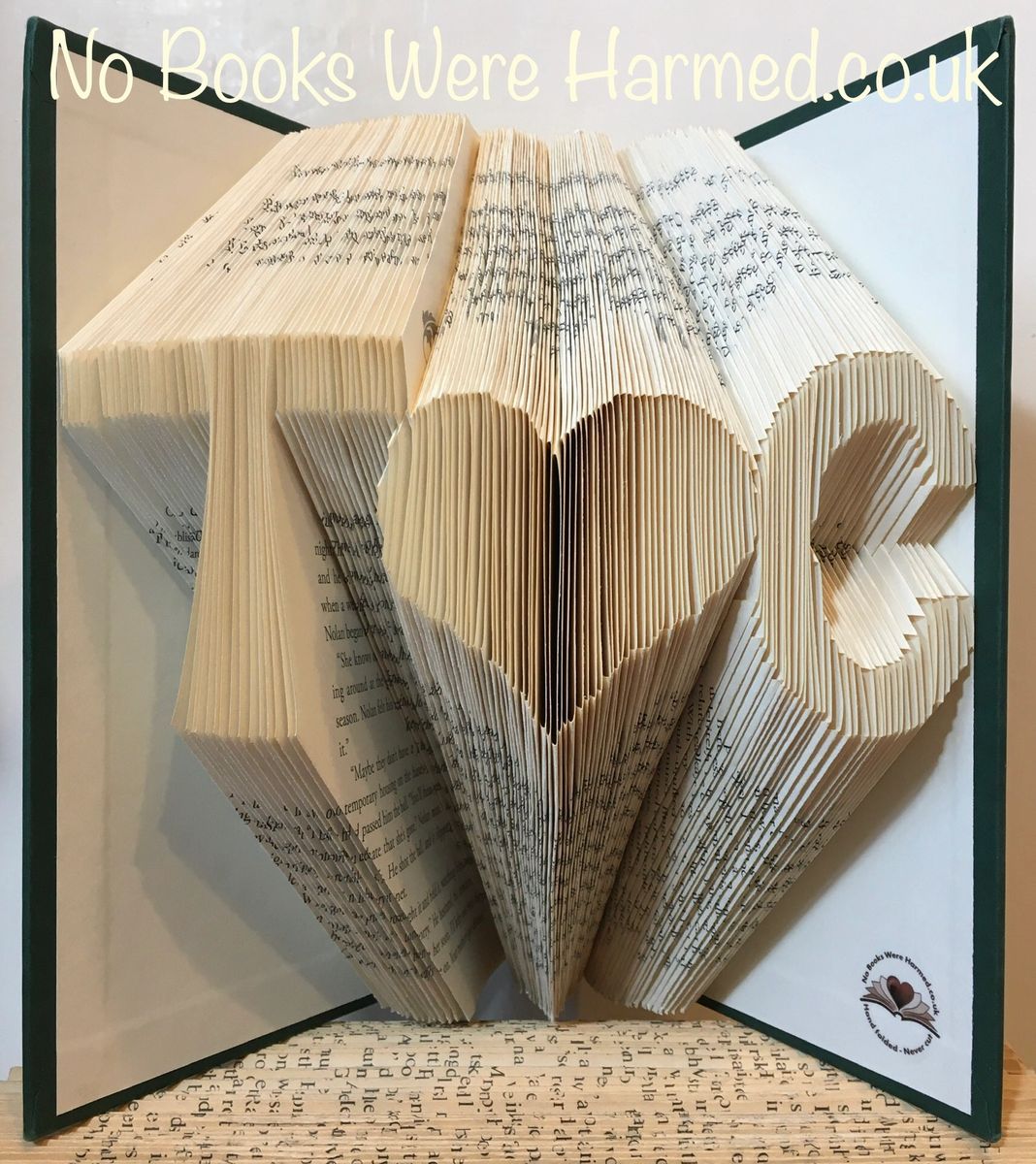 Personalized book art featuring initials beside a love heart, handcrafted from vintage pages.