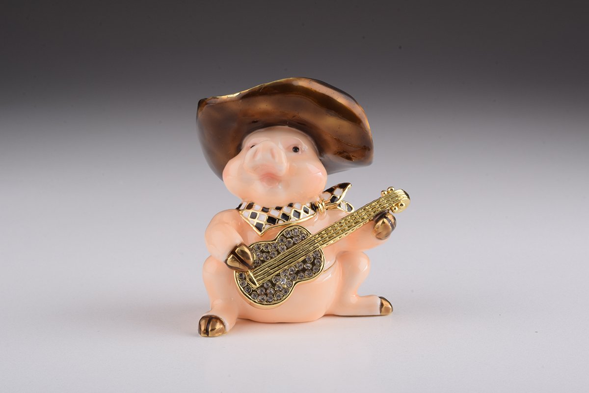 A charming enamel painted trinket box shaped like a pig playing guitar, adorned with Austrian crystals and gold plating.