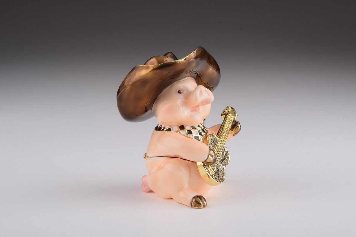 A charming enamel painted trinket box shaped like a pig playing guitar, adorned with Austrian crystals and gold plating.