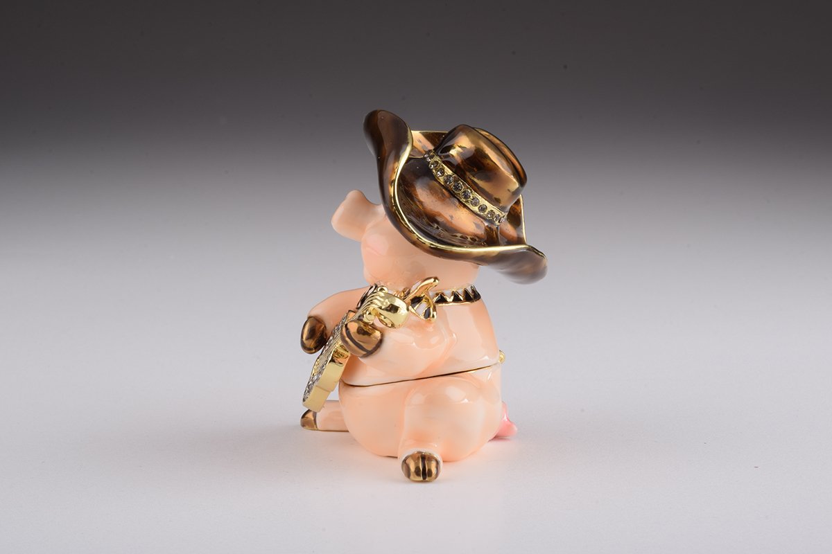 A charming enamel painted trinket box shaped like a pig playing guitar, adorned with Austrian crystals and gold plating.