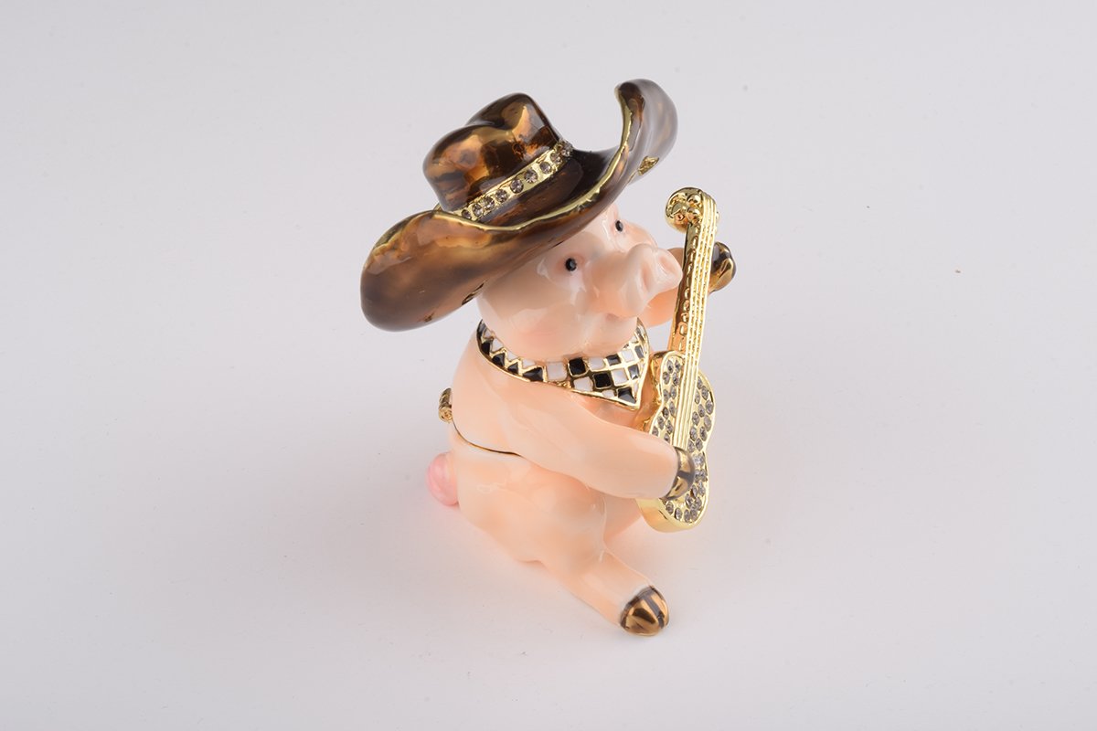 A charming enamel painted trinket box shaped like a pig playing guitar, adorned with Austrian crystals and gold plating.