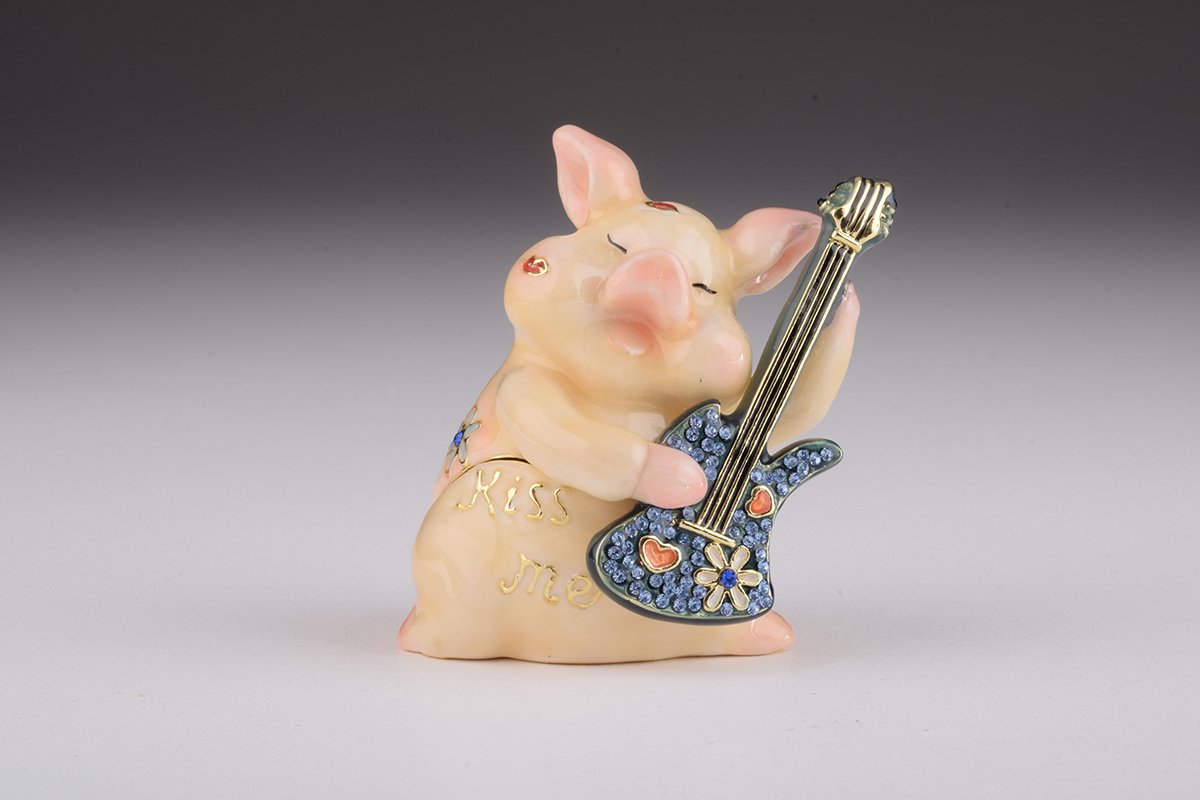 A beautifully crafted enamel trinket box featuring a pig playing guitar, adorned with sparkling Austrian crystals and plated with gold or silver.