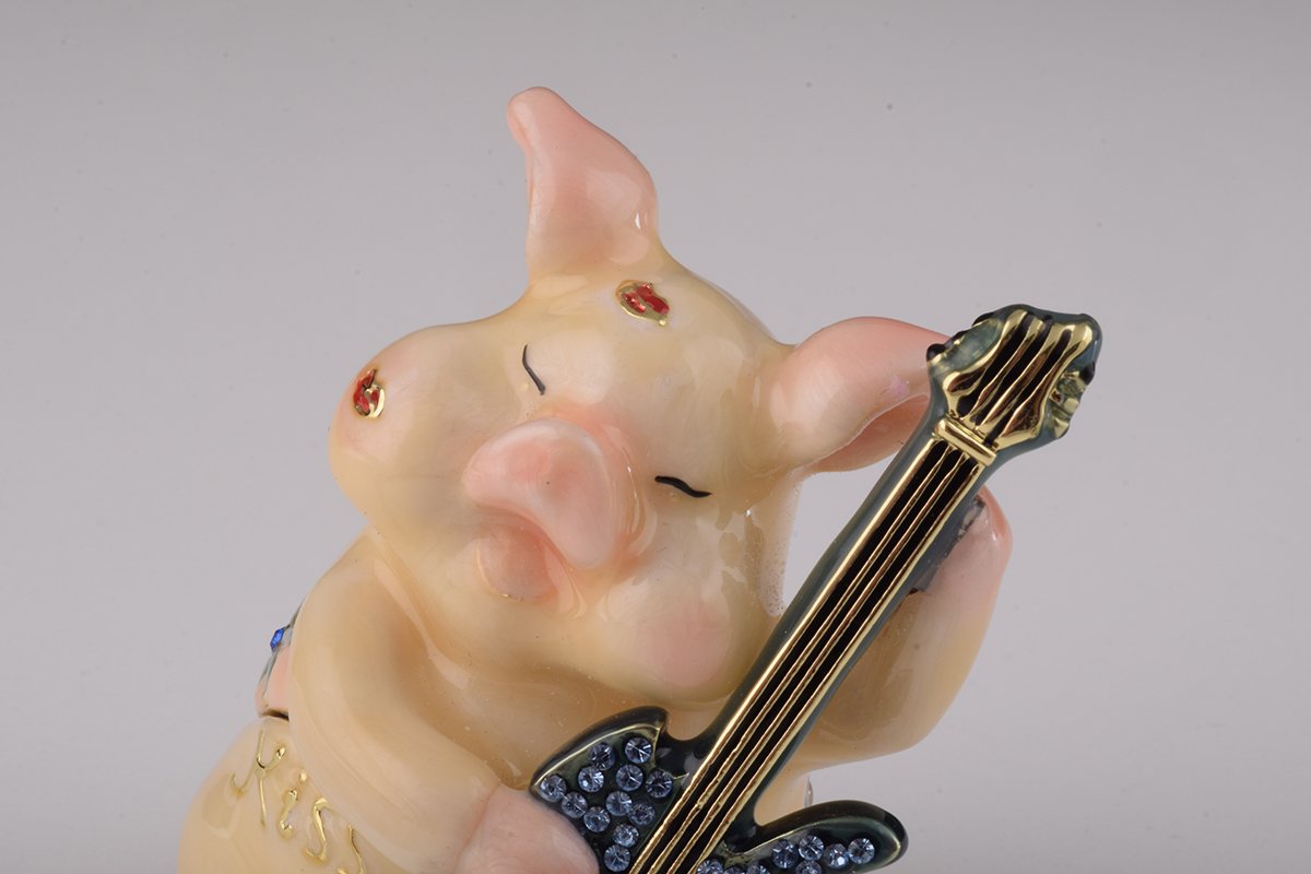 A beautifully crafted enamel trinket box featuring a pig playing guitar, adorned with sparkling Austrian crystals and plated with gold or silver.