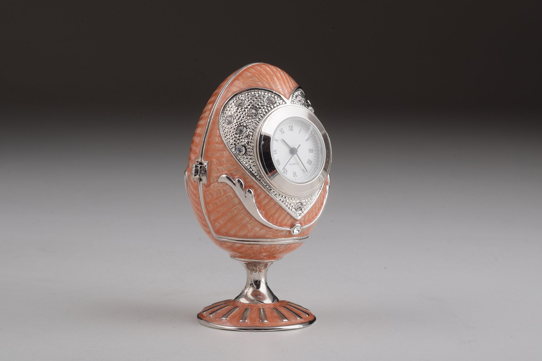 A stunning pink Faberge egg trinket box with clock, adorned with sparkling Austrian crystals and featuring a luxurious gold or silver plating.