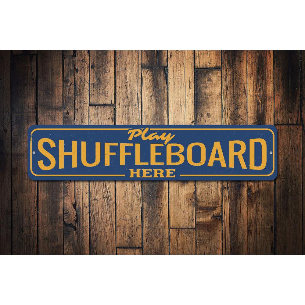 A decorative Play Shuffleboard Here Sign made of high-quality aluminum, featuring vibrant colors and customizable text, perfect for game rooms.