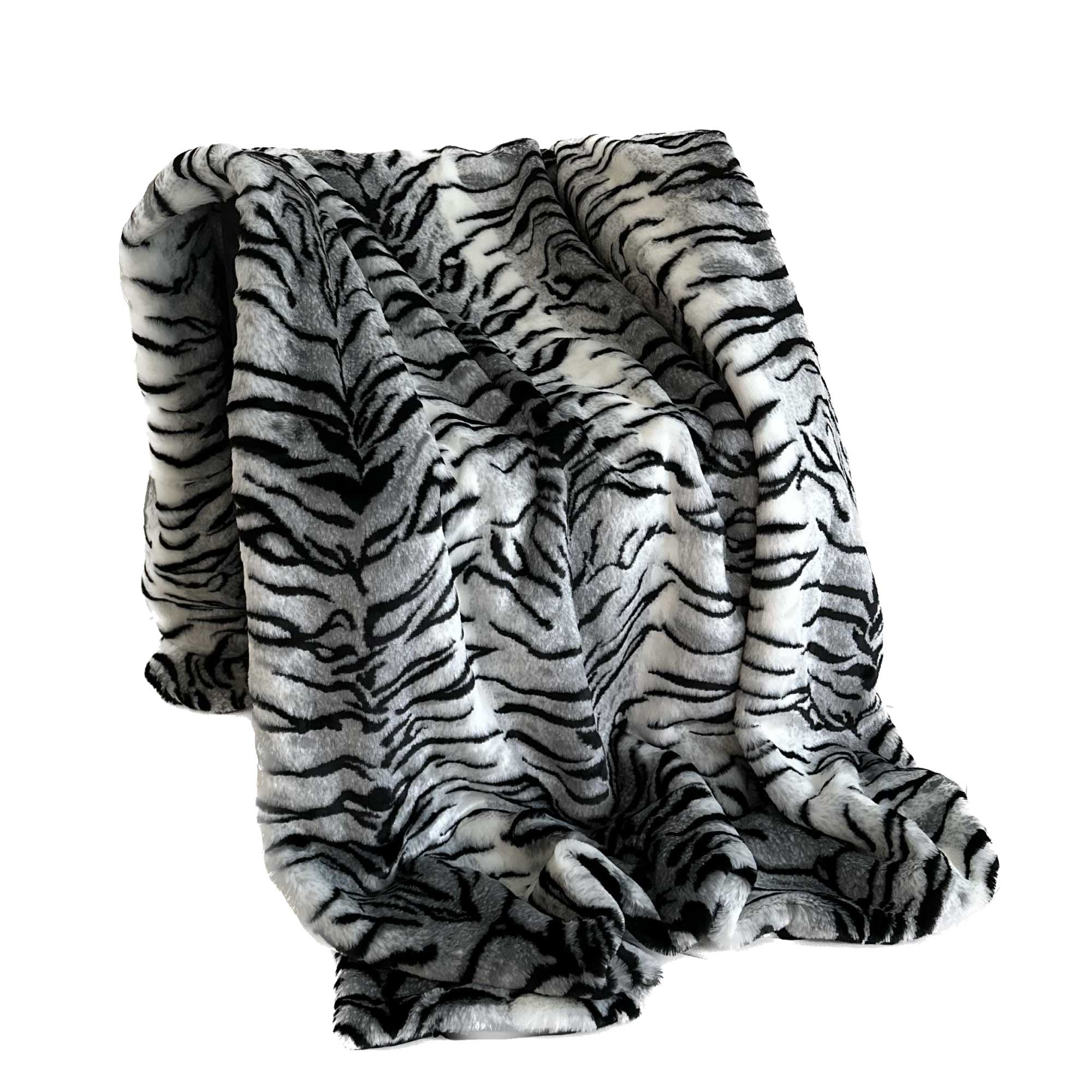 Plutus Black and White Zebra Faux Fur Luxury Throw Blanket draped elegantly over a sofa, showcasing its fluffy texture and stylish design.