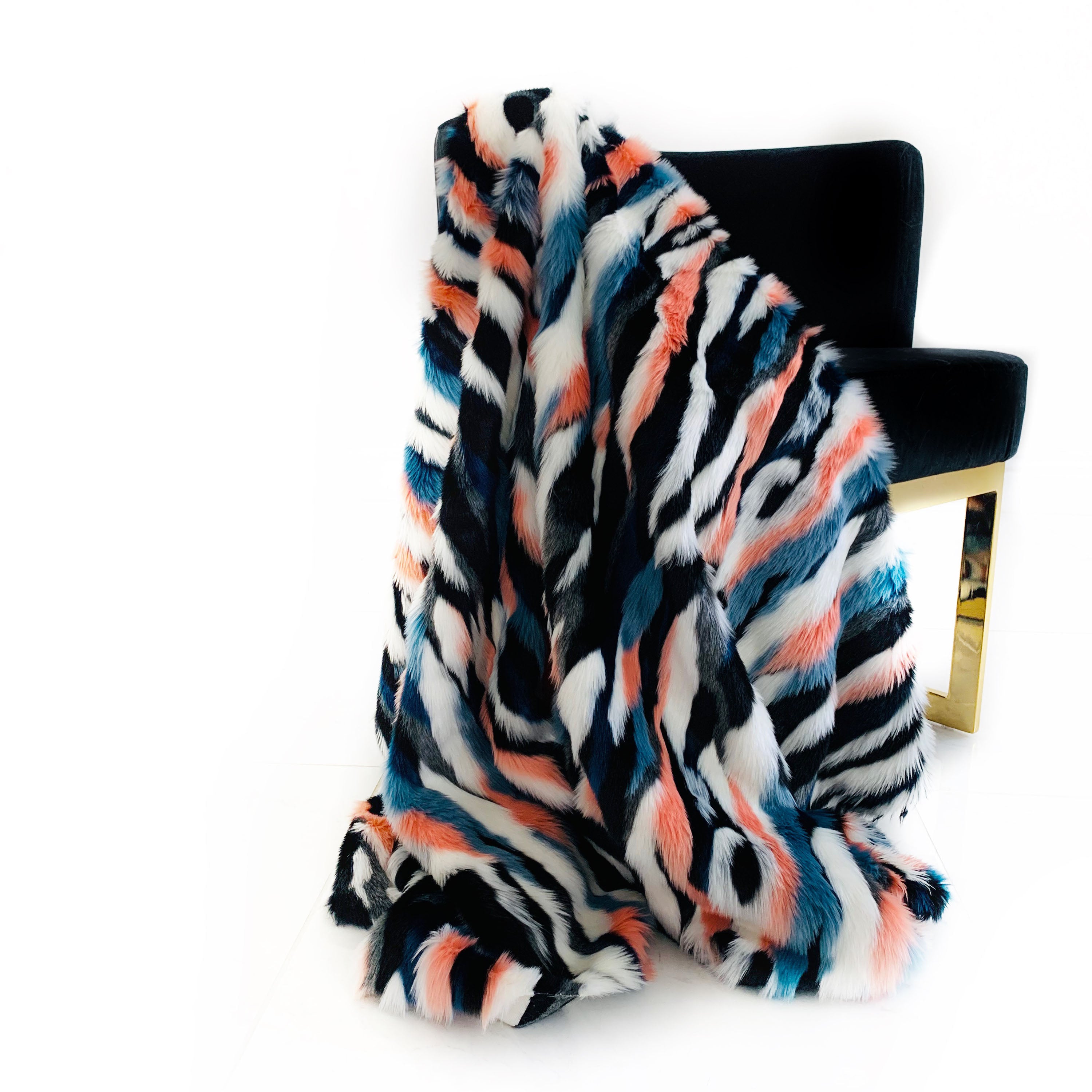 Plutus Black, Blue, Pink Unicorn Faux Fur Luxury Throw Blanket draped elegantly over a sofa, showcasing its plush texture and vibrant colors.