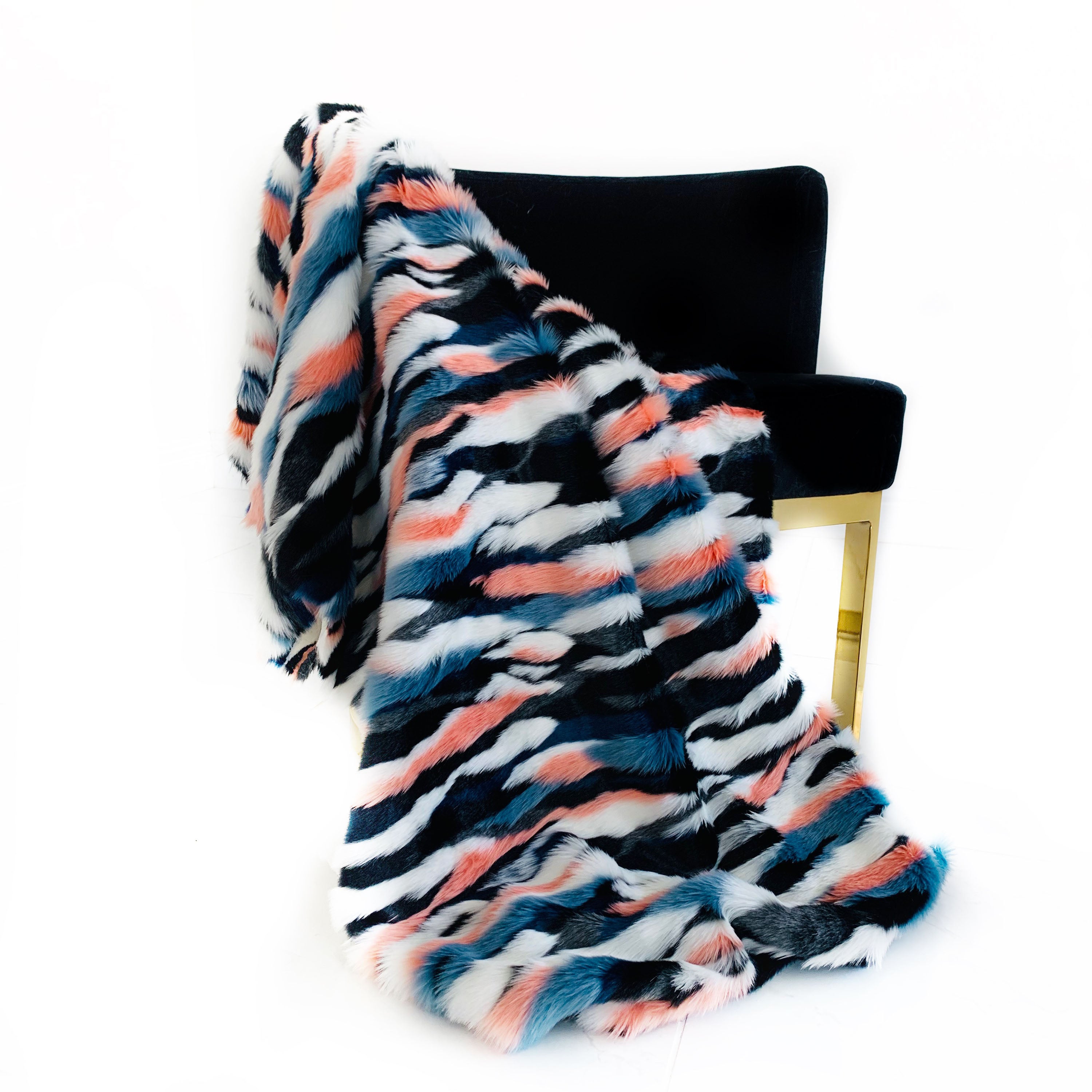 Plutus Black, Blue, Pink Unicorn Faux Fur Luxury Throw Blanket draped elegantly over a sofa, showcasing its plush texture and vibrant colors.