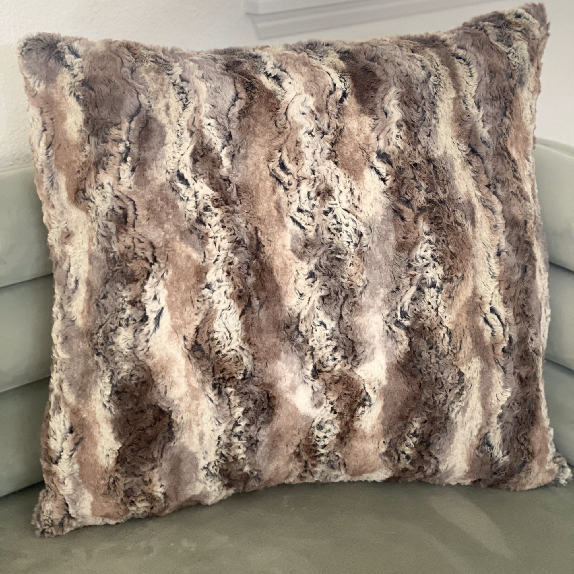 Plutus Brands Elegant Brandy Pillow in light brown, gold, and white with animal motif, showcasing its luxurious handmade design.