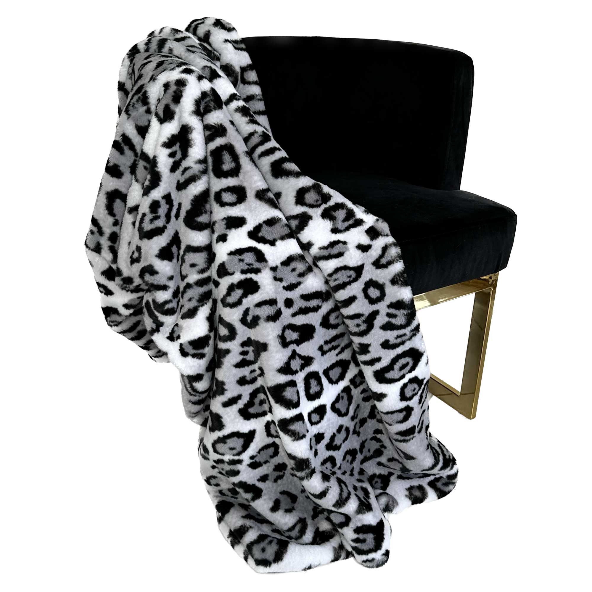 Plutus Gray Silver Jaguar Faux Fur Luxury Throw Blanket draped elegantly over a couch, showcasing its plush texture and stylish design.